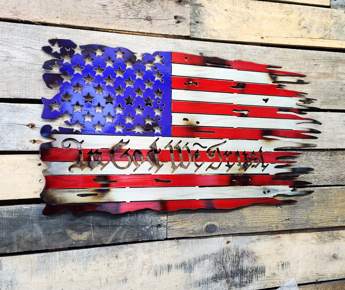 tattered battle worn metal flag in god we trust